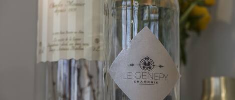 Una botella con una etiqueta que dice "LE GENERY CHAMONIX" y un menú al fondo.