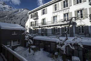 Un hotel con balcón y vista a la montaña.