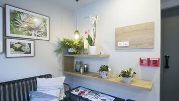 Una sala de estar moderna con un sofá, una mesita de centro y estantes empotrados con plantas y objetos decorativos.