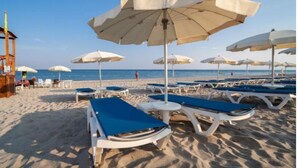 A beach with sun loungers, umbrellas, and a lifeguard tower. - TH Simeri - Simeri Village (Simeri-Crichi)