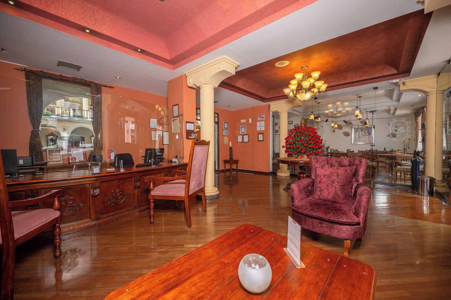 A spacious lobby with a reception desk, a plush armchair, and a chandelier.