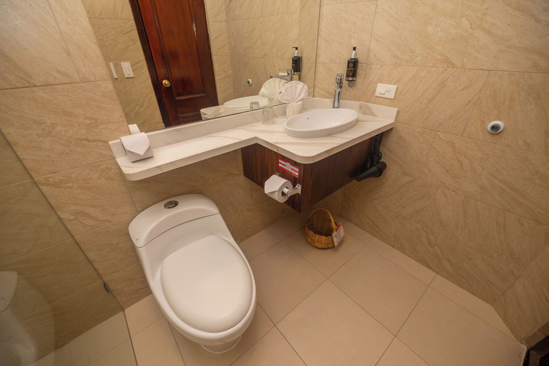 A modern bathroom with a toilet, sink, and a towel rack.