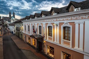En historisk gade med traditionel arkitektur, herunder dekorative gavle og en markant kirke i baggrunden.