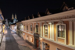En historisk gade med udsmykkede bygninger, en katedral i baggrunden og frit udsyn over gaden.
