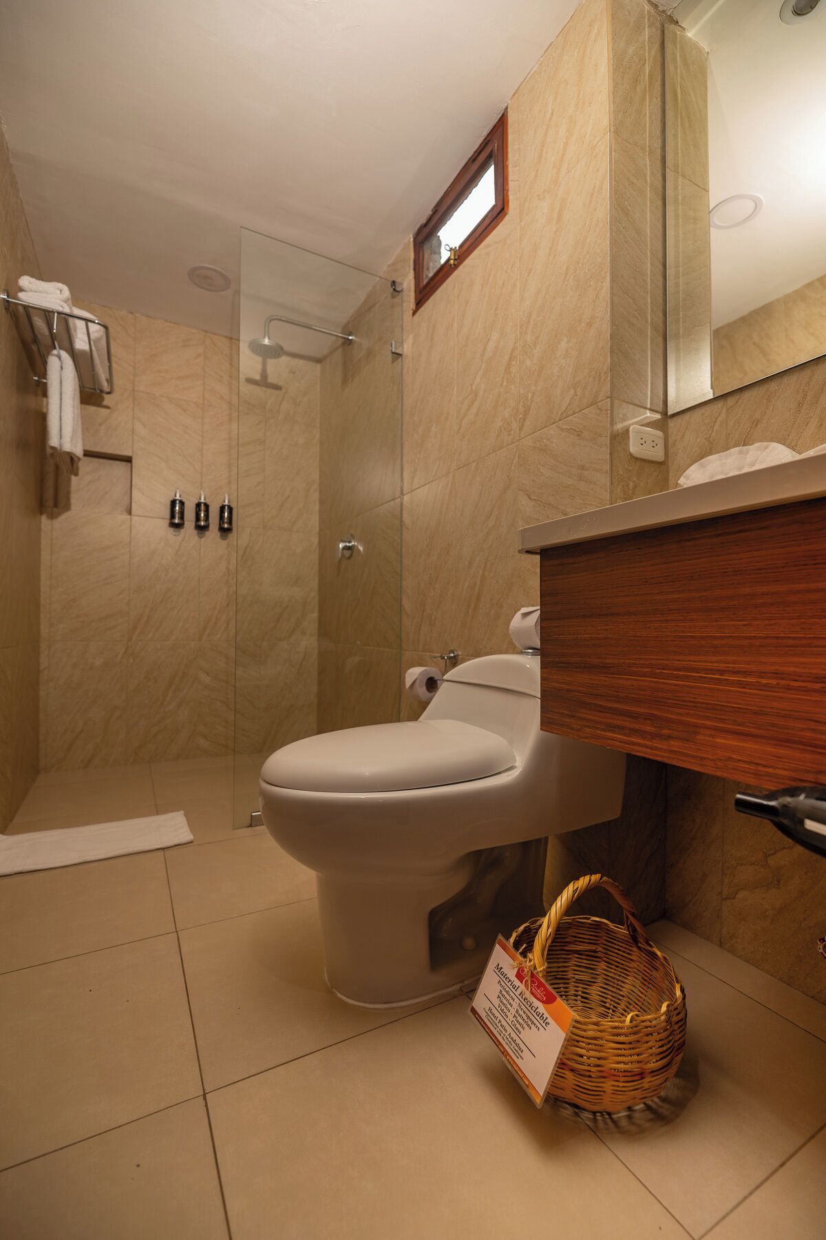 A bathroom with a toilet, a shower, and a sink.