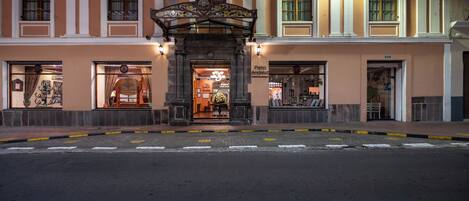 A building facade with ornate architectural details, large windows, and a central entrance with a decorative arch.