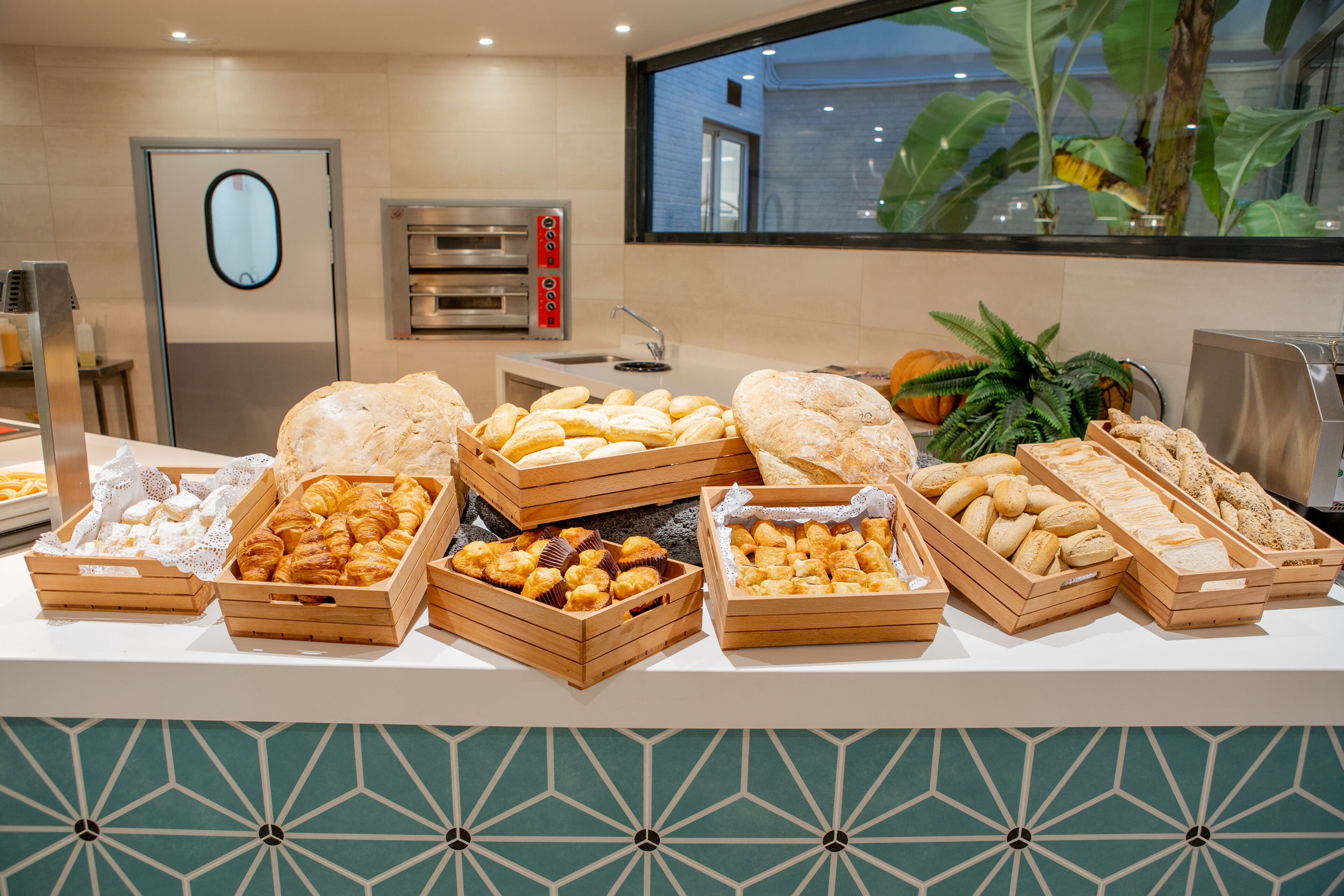 A buffet with various baked goods and pastries in wooden boxes.