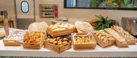Un buffet proposant une variété de produits de boulangerie et de pâtisserie, présentés dans des boîtes en bois.