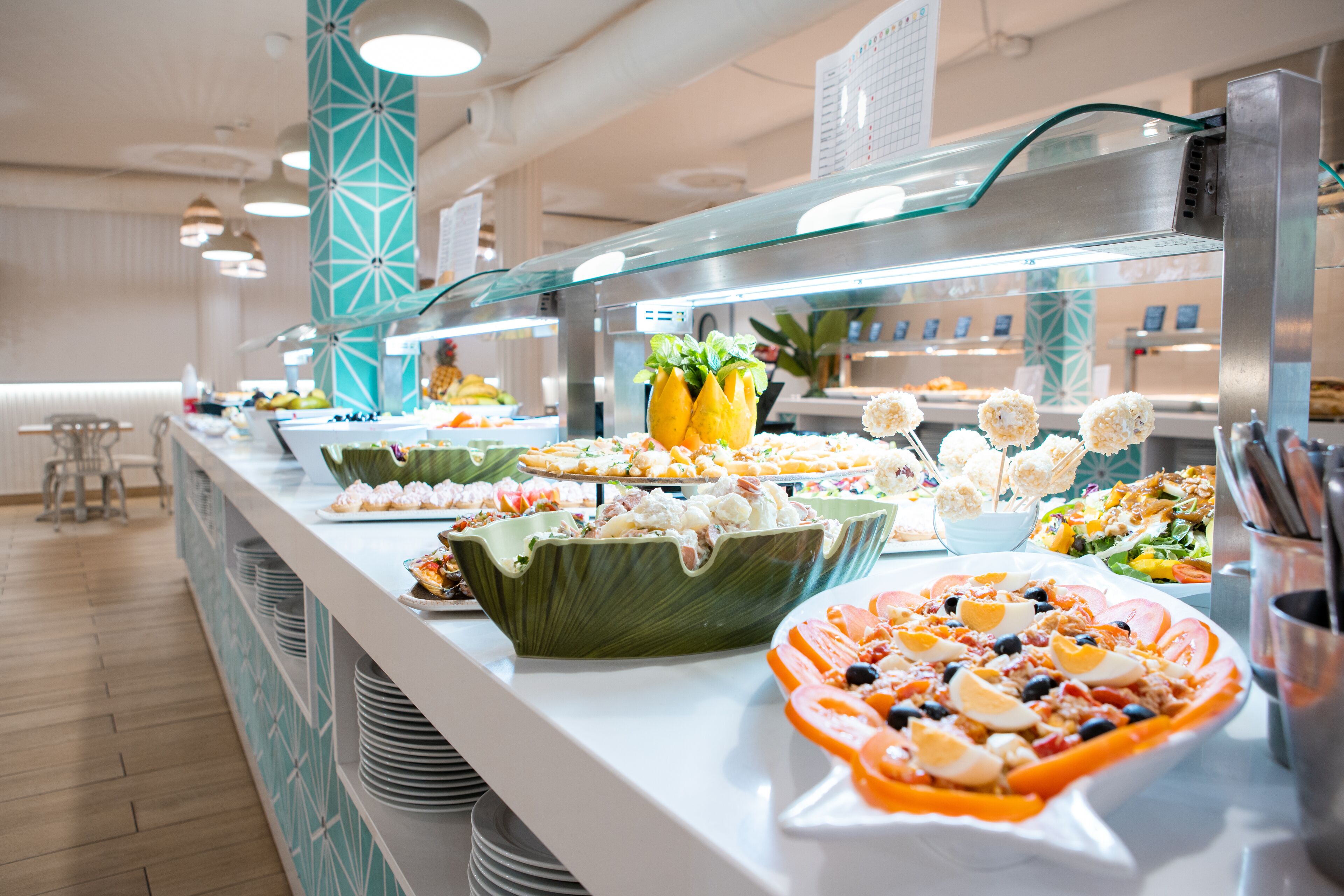 Een buffet met diverse gerechten en een zithoek op de achtergrond.