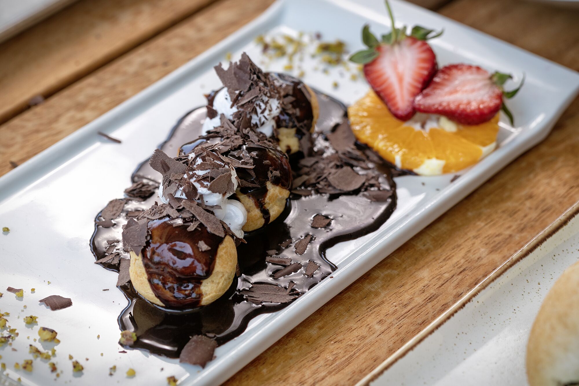 A dessert plate with chocolate sauce, strawberries, and orange slices.