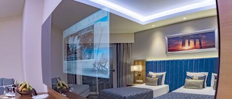 Una habitación de hotel con cama, mesita de noche y televisor en la pared.