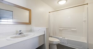 A bathroom with a sink, toilet, and shower. - Budget Inn and Suites (Stockton)