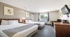 A hotel room with two beds, a desk with a computer, a TV, and a window with curtains. - Budget Inn and Suites (Stockton)