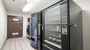 Un couloir avec des distributeurs automatiques et une porte.