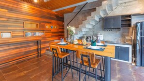 A modern kitchen with a wooden bar area, a staircase, and a clock on the wall. - Aonang Paradise Resort (Krabi)