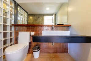 A bathroom with a toilet, sink, and trash can. - Aonang Paradise Resort (Krabi)