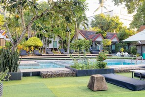 A pool area with lounge chairs, a small pool, and surrounding greenery. - Aonang Paradise Resort (Krabi)