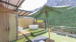 A spa area with a hot tub, outdoor seating, and a view of a mountainous landscape. - Aonang Paradise Resort (Krabi)