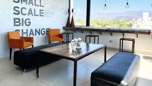A modern room with a large window, a wall with motivational text, and a minimalist furniture arrangement. - Hotel Internacional (Mendoza)