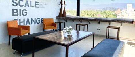A modern room with a large window, a wall with motivational text, and a minimalist furniture arrangement.