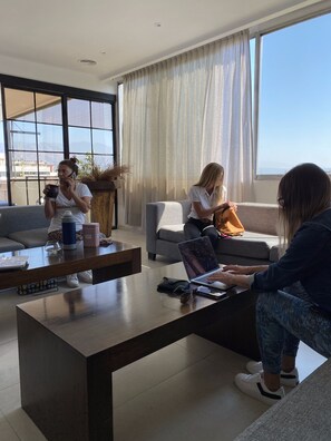 A modern living room with a large window, a coffee table, and a sofa. - Hotel Internacional (Mendoza)