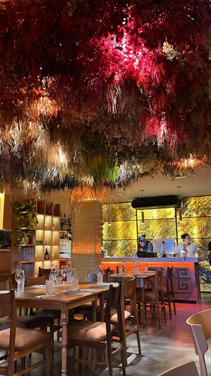 A restaurant interior with tables set for dining, a bar area, and a decorative ceiling. - Hotel Internacional (Mendoza)