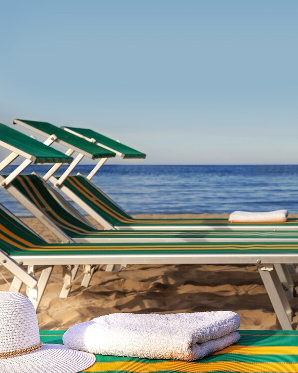 Plage, chaises longues, parasols