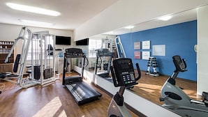 Academia com esteiras, elípticos e equipamentos de musculação.