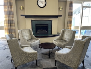Relax in style with a fireplace, comfortable armchairs, and a coffee table.