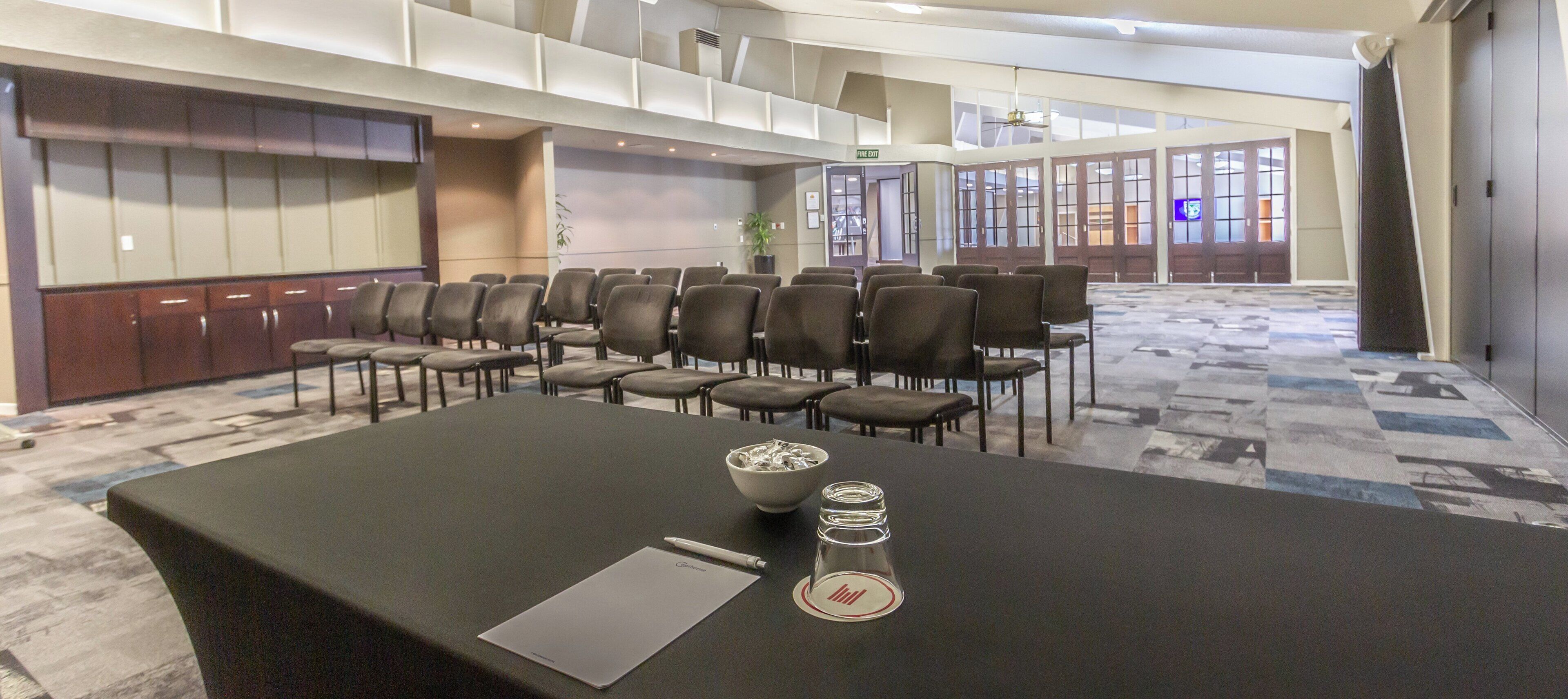 Una sala de conferencias con una larga mesa, sillas y una pizarra.