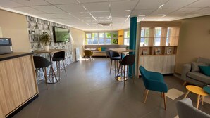 Un intérieur moderne comprenant un espace cuisine, un coin repas et un espace détente.