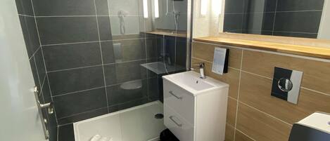 Un bagno moderno con doccia vetrata, lavandino bianco e water.