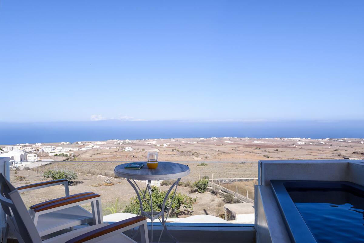 Un balcon avec une table, des chaises et une vue sur la mer.