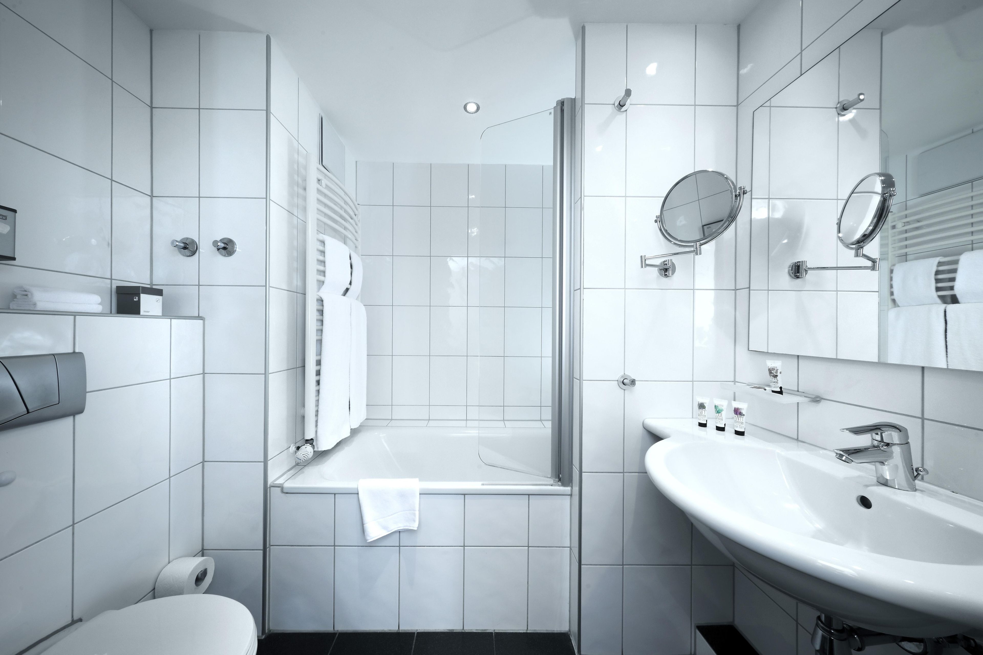 A modern bathroom with a shower, toilet, and sink.