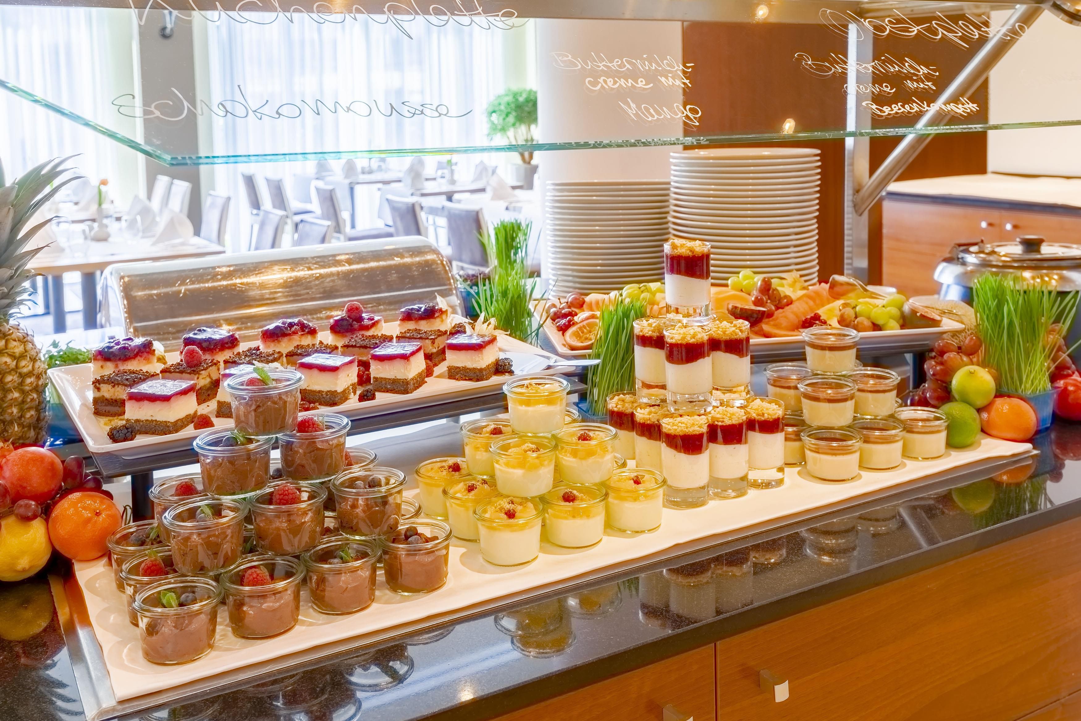 Un bufé con diversos postres y frutas.