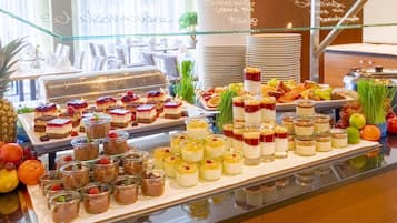 Un bufé con diversos postres y frutas.