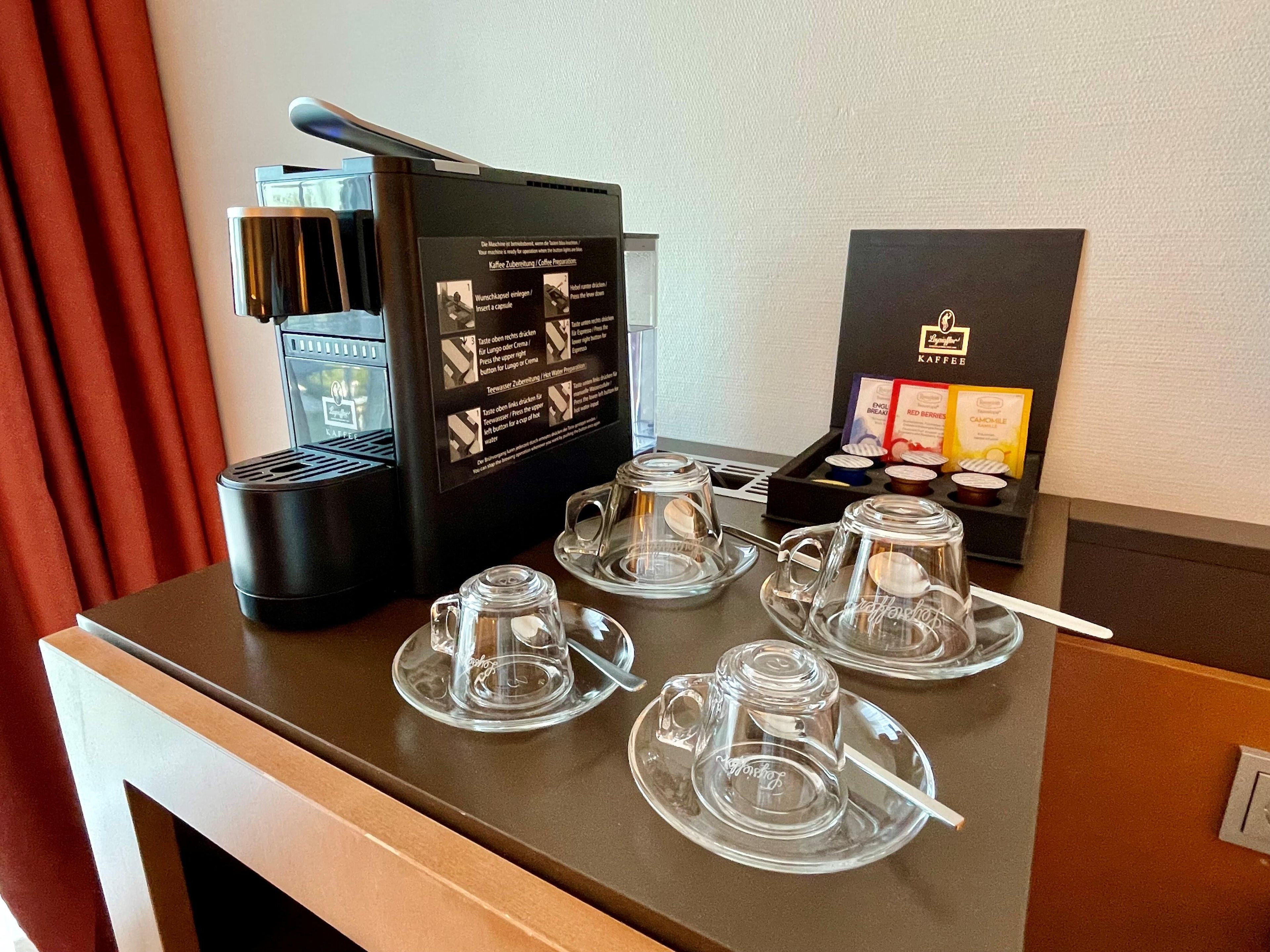 A coffee station with a coffee machine, cups, and a menu.