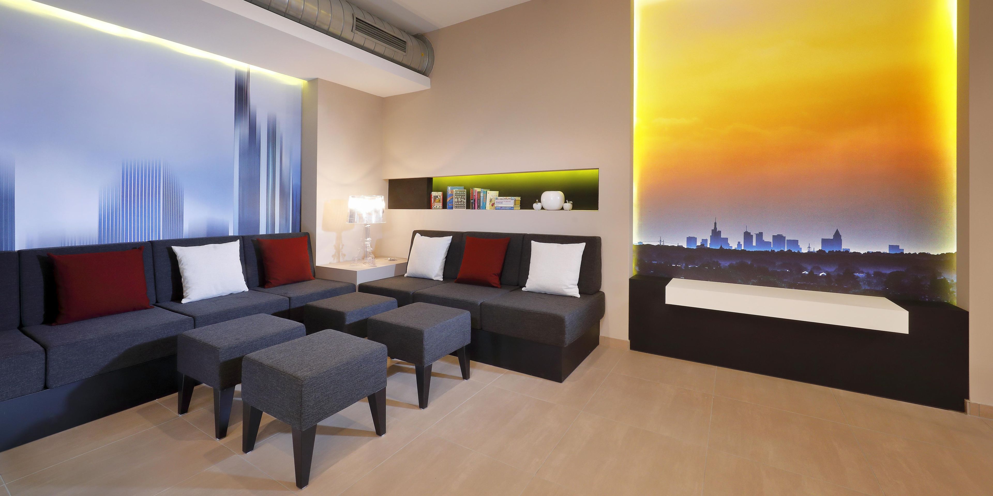 Een moderne hotelkamer met een zithoek, een salontafel en uitzicht op de stad.
