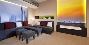 A modern hotel room with a sofa set, a coffee table, and a cityscape view. - Best Western Premier IB Hotel Friedberger Warte (Frankfurt)