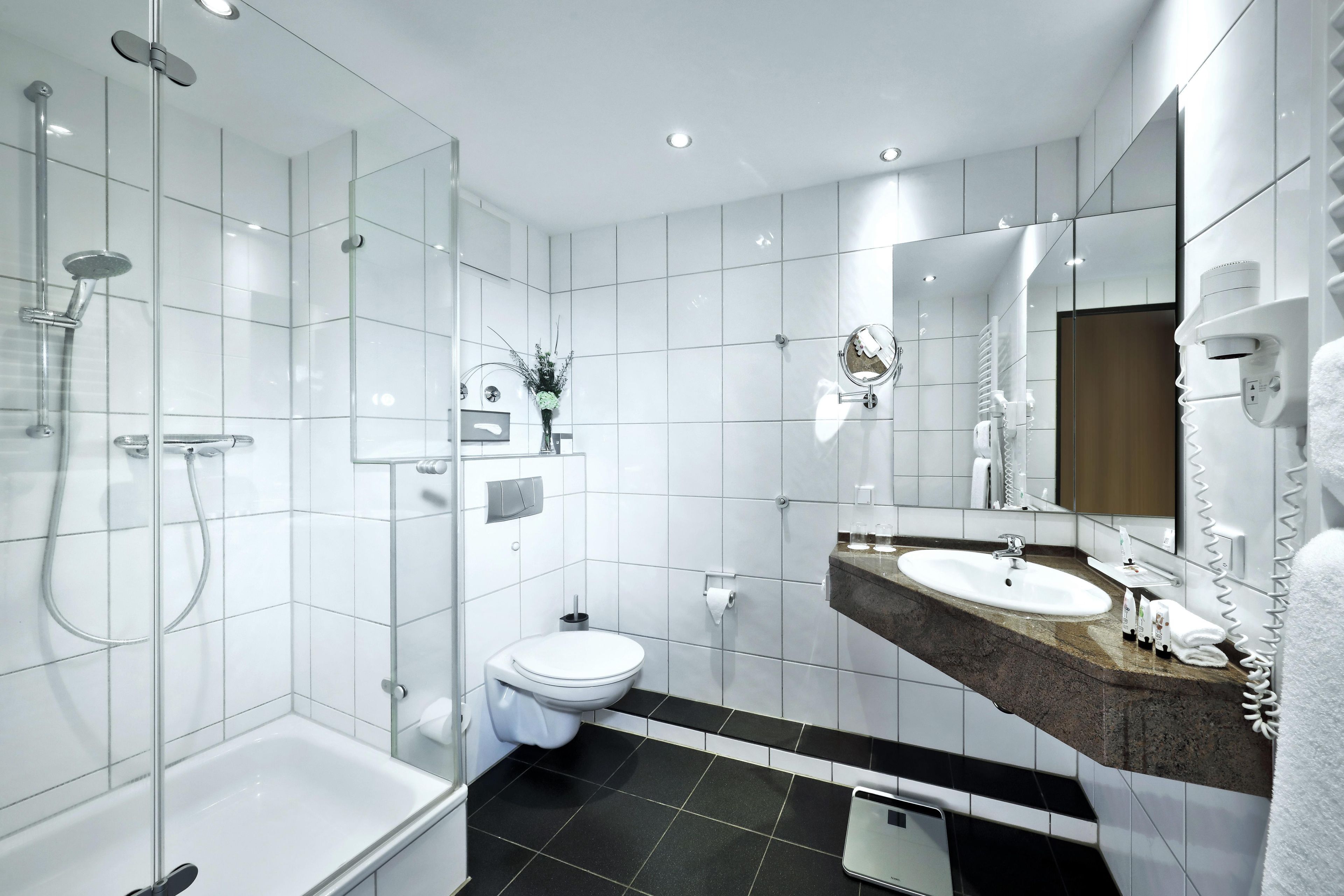 Ein modernes Badezimmer mit Badewanne, Toilette und Dusche.