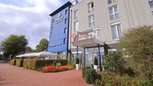 A hotel with a blue and grey facade, outdoor seating area, and a sign for 'Premier Best Western'. - Best Western Premier IB Hotel Friedberger Warte (Frankfurt)
