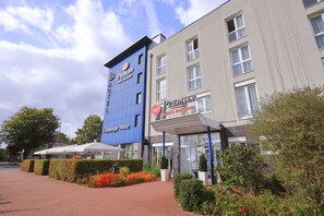 A hotel with a blue and grey facade, outdoor seating area, and a sign for 'Premier Best Western'. - Best Western Premier IB Hotel Friedberger Warte (Frankfurt)