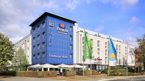 A hotel with a blue facade, outdoor seating, and flags. - Best Western Premier IB Hotel Friedberger Warte (Frankfurt)