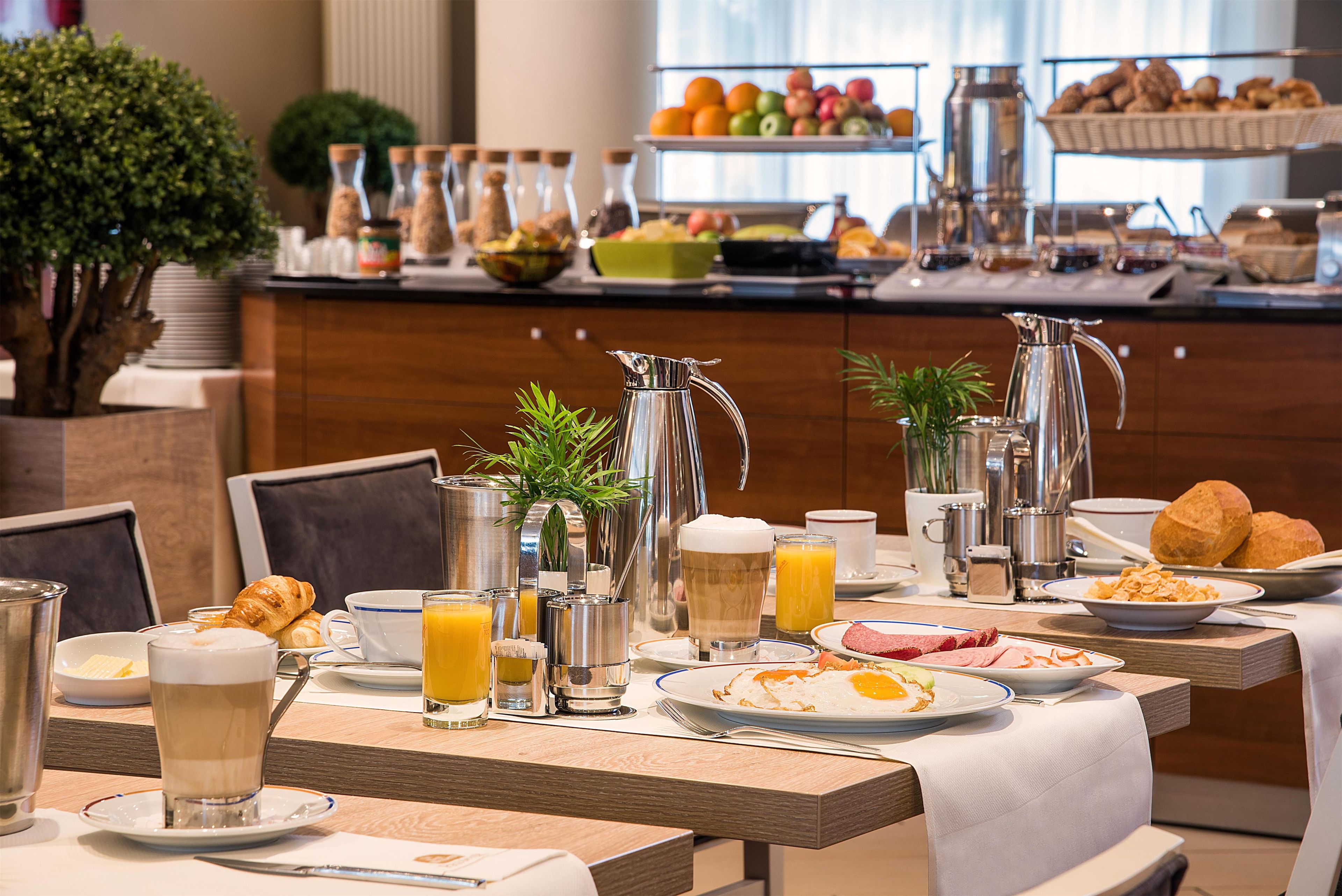 A breakfast buffet with various food items, beverages, and condiments.