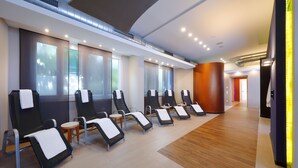A modern spa room with multiple massage chairs, a wooden floor, and a large window providing natural light. - Best Western Premier IB Hotel Friedberger Warte (Frankfurt)