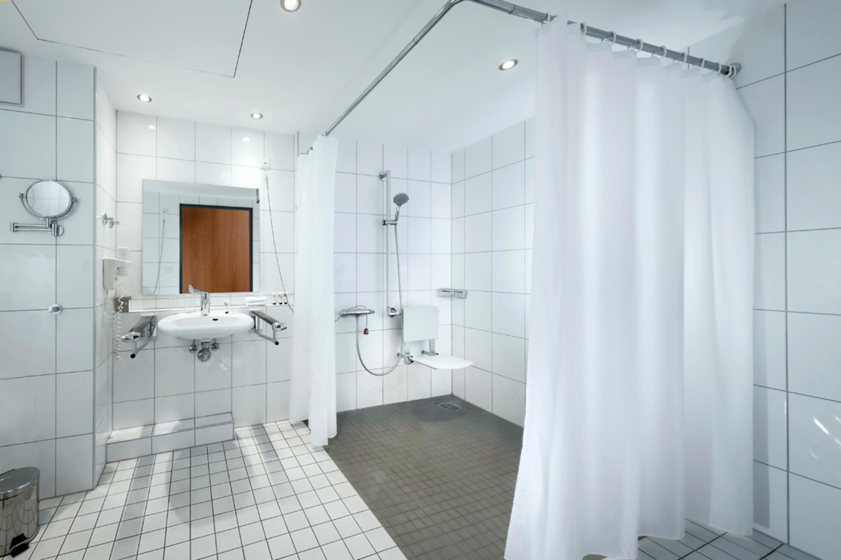 Ein modernes Badezimmer mit Waschbecken, Spiegel und Dusche.