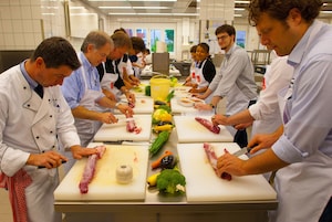 Un gruppo di chef che preparano cibo in una cucina professionale.
