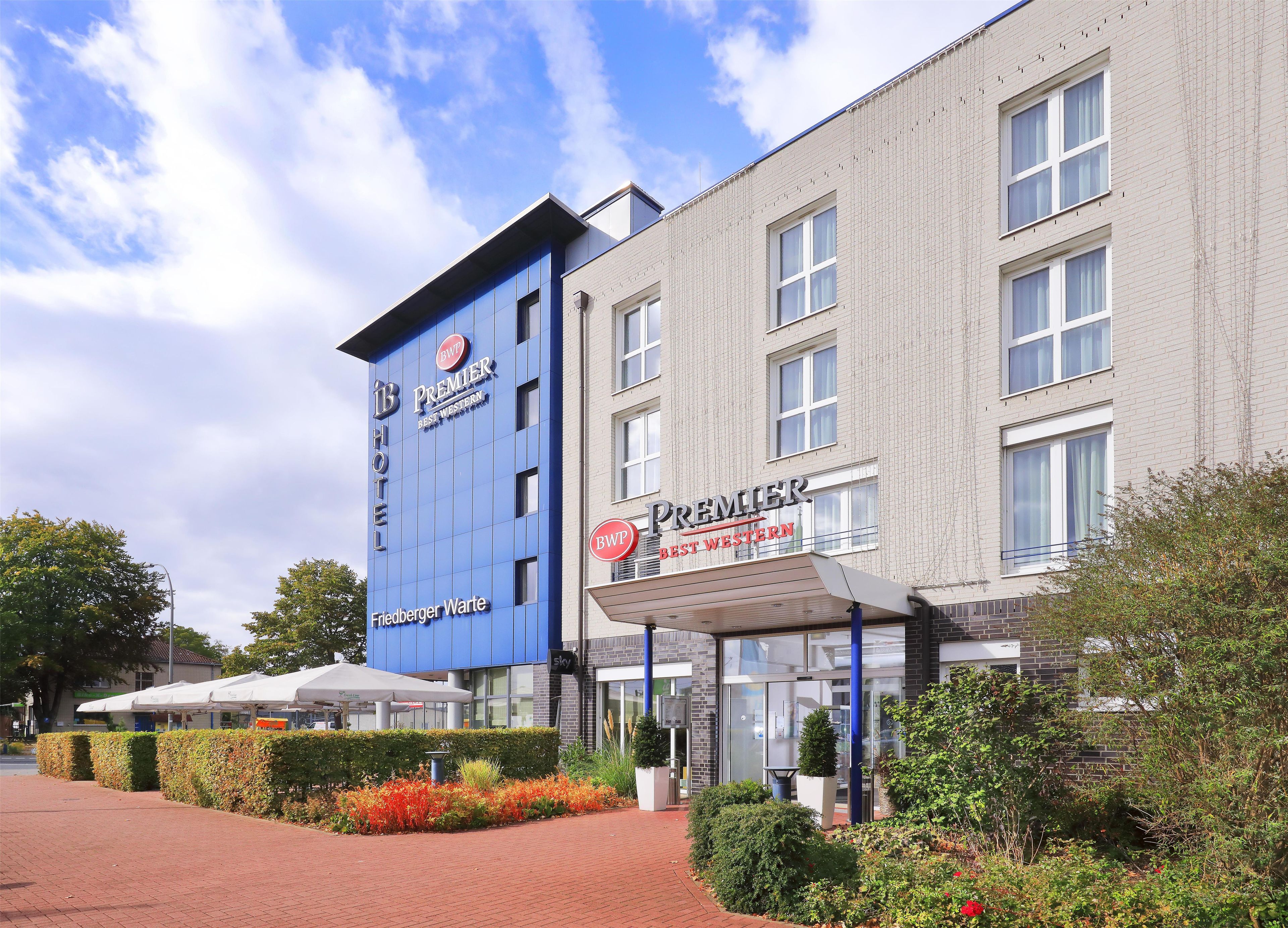 Un hotel con una fachada azul destacada y señalización que indica que es un Best Western Premier.