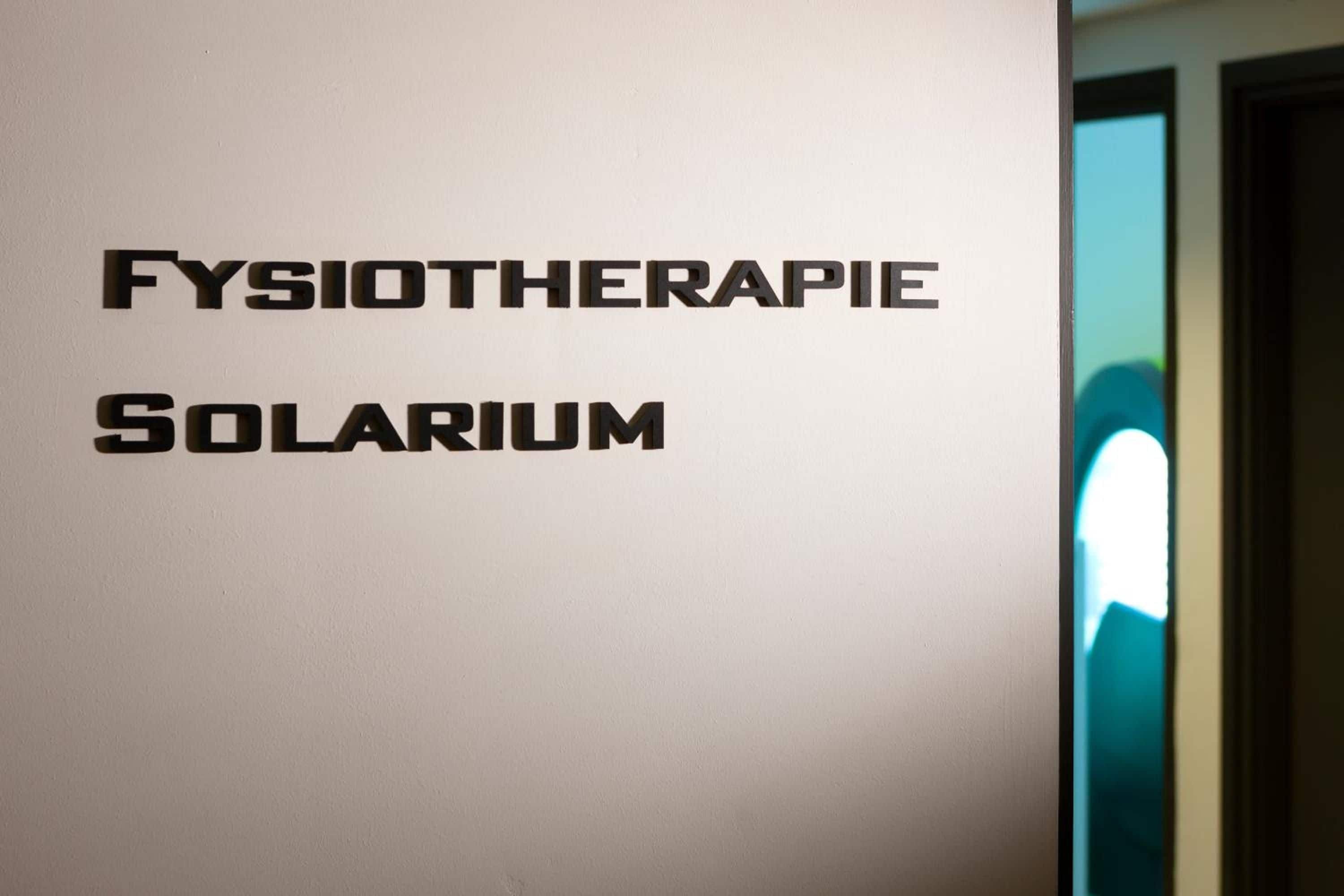A wall with the words 'FYSIOTHERAPIE SOLARIUM' indicating a physiotherapy facility.