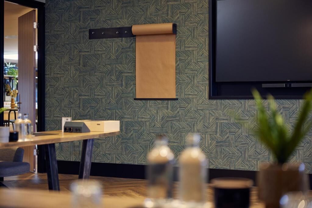 Een modern interieur met een patroonmuur, een flatscreen televisie, een houten tafel en een plant.